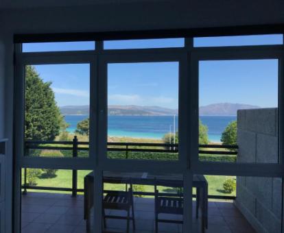 Foto del comedor acristalado con vistas al mar del apartamento.
