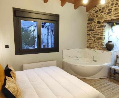 Dormitorio con jacuzzi privado junto a la cama de este apartamento independiente.