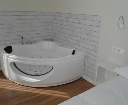 Jacuzzi privado junto a la cama del apartamento superior.