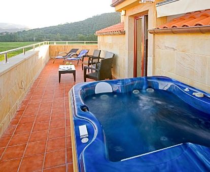 Terraza con mobiliario y un gran jacuzzi privado al aire libre del apartamento superior de este complejo.