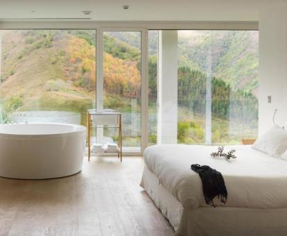 Suite de dos dormitorios con bañera circular con chorros y vistas a la naturaleza.