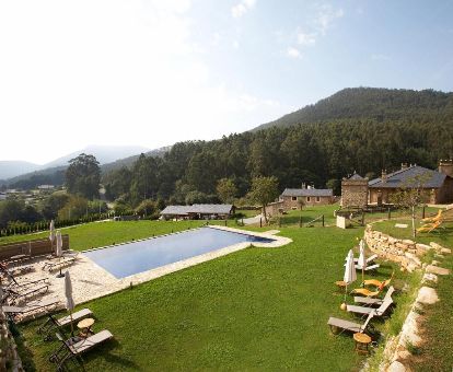 Amplia zona exterior ajardinada con piscina y vistas a la naturaleza en este maravilloso hotel rural.