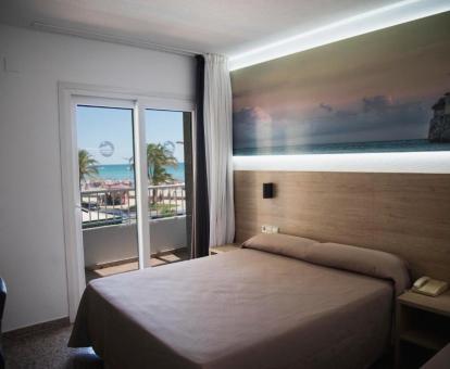 Foto de una de las luminosas habitaciones del hotel con terraza y vistas al mar.