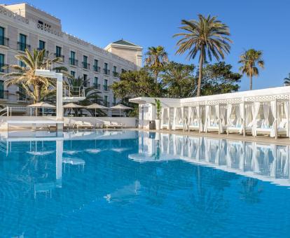 Foto de la piscina al aire libre con camas balinesas del resort.