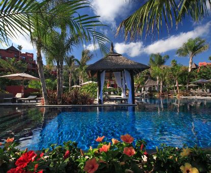 Fabulosa zona exterior con vegetación, piscinas y palafitos independientes de este espectacular hotel ideal para parejas.