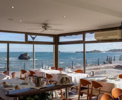 Foto del comedor acristalado con vistas al mar del hotel.