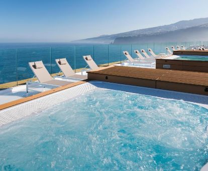 Terraza solarium con vistas al mar y jacuzzis exteriores en este moderno hotel solo para adultos.