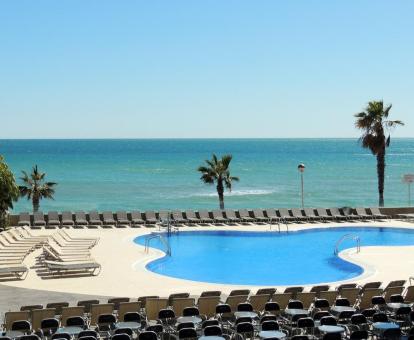 Foto de la piscina al aire libre con solarium y vistas al mar.