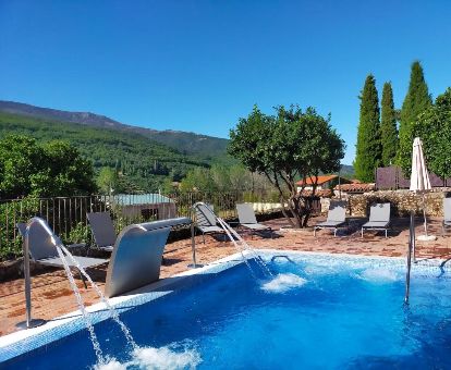 Acogedora piscina exterior con elementos de hidroterapia y vistas a las montañas de este romántico hotel.