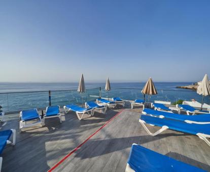 Foto del solarium con tumbonas y vistas al mar del hotel.