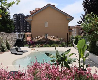Agradable zona exterior de este romántico hotel con piscina de tipo laguna y solarium.