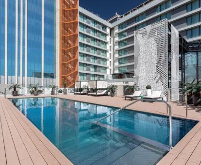Foto de la piscina con solarium y tumbonas del hotel.