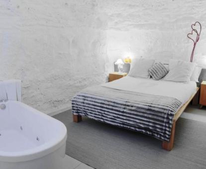 Foto de la Suite rústica con bañera de hidromasajes cerca de la cama.