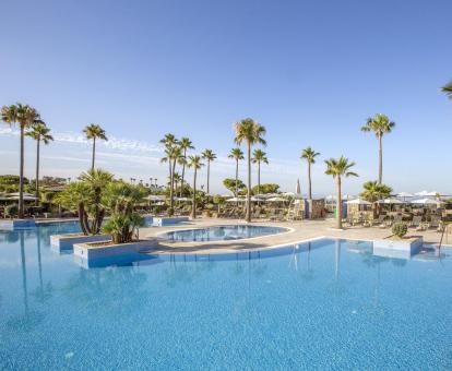 Foto de la piscina con solarium y tumbonas del hotel.