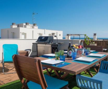 Foto de la amplia terraza con zona de barbacoa y vistas al mar del apartamento.