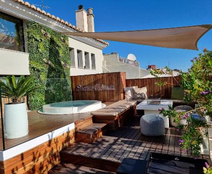 Hermosa terraza con mobiliario y jacuzzi en este hotel ideal para parejas.