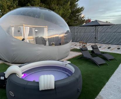 Romántica habitación burbuja con jardín y jacuzzi al aire libre.