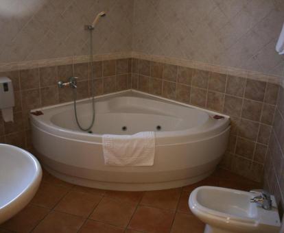 Bañera de hidromasaje privada en el baño de la habitación doble superior con terraza del hotel.
