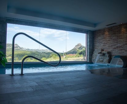 Agradable zona de bienestar con piscina cubierta y vistas a la naturaleza de este acogedor hotel.