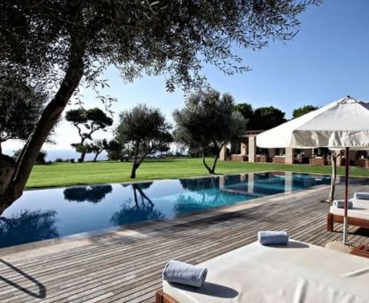 Gran zona exterior de este romántico hotel con piscina al aire libre y solarium con vistas al mar.