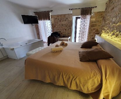 Habitación doble deluxe con jacuzzi privado junto a la cama de este coqueto hotel perfecto para parejas.
