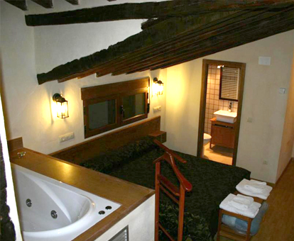 Foto de la habitación con bañera de hidromasaje al lado de la cama de la Casa Spa del Renacimiento
