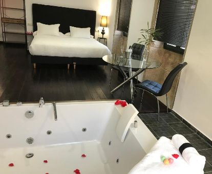 Dormitorio con jacuzzi privado junto a la cama de la casa de un dormitorio de este hotel romántico.