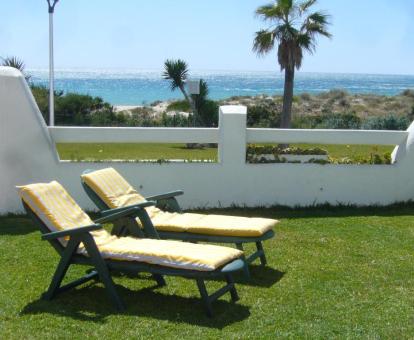 Foto del jardín privado con tumbonas y vistas al mar de la casa.