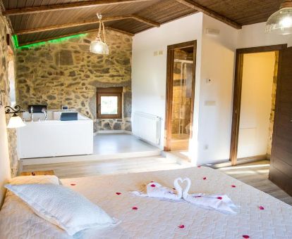 Suite Deluxe con bañera de hidromasaje junto a la cama de este alojamiento romántico.