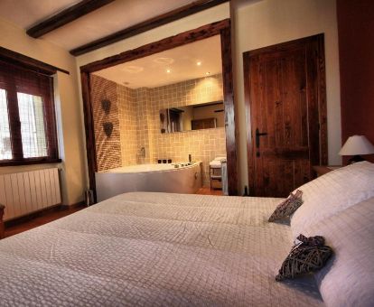 Dormitorio con jacuzzi privado cerca de la cama del apartamento de un dormitorio de este establecimiento rural.