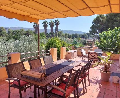 Agradable terraza con mobiliario y vistas a la naturaleza que rodea este acogedor establecimiento rural.