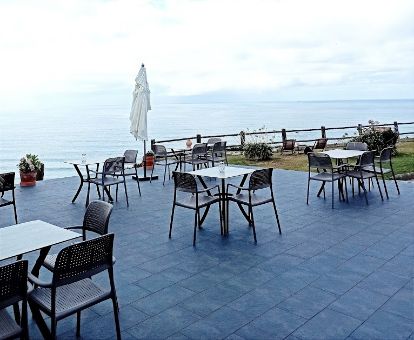 Terraza con comedores y vistas al mar de este acogedor hotel en un tranquilo entorno para descansar.