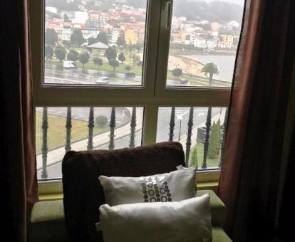 Foto de la ventana con vistas al mar y a la ciudad del apartamento.