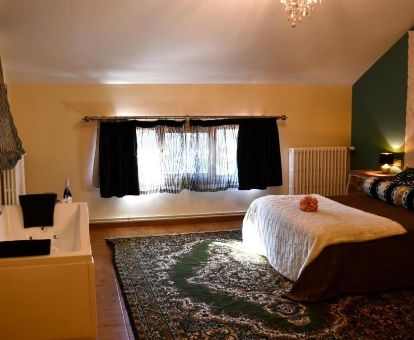 Coqueta habitación doble con bañera de hidromasaje privada junto a la cama en este hotel rural.