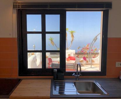 Foto de la ventana de la cocina de uno de los apartamentos con vistas a la terraza y al mar.