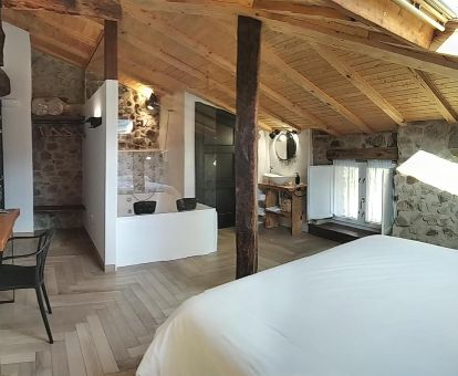 Hermosa habitación doble con bañera de hidromasaje privada cerca de la cama en este hotel rural.