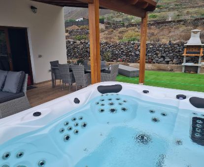Zona exterior con jacuzzi privado, barbacoa y mobiliario de esta casa independiente.
