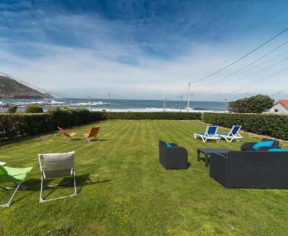 Foto del amplio jardín con mobiliario exterior y vistas al mar del alojamiento.