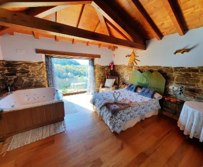 Dormitorio con un gran jacuzzi privado junto a la cama de la casa de un dormitorio de este alojamiento rural.