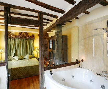Habitación de estilo tradicional con bañera de hidromasaje privada de este hotel rural.