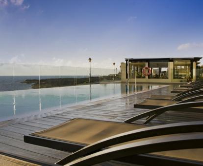 Foto de una de las piscinas del hotel con borde infinito y vistas panorámicas al mar.