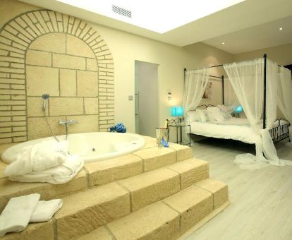 Hermosa suite con bañera de hidromasaje privada junto a la cama de este espectacular hotel.