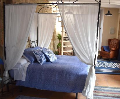 Una de las acogedoras habitaciones con cama con dosel de este coqueto hotel ideal para parejas.