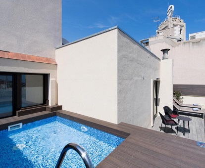 Foto de la piscina privada cuadrada en lo alto de un altillo en la terraza de la Suite Junior y donde se ven las hamacas y resto de mobiliario de la terraza.
