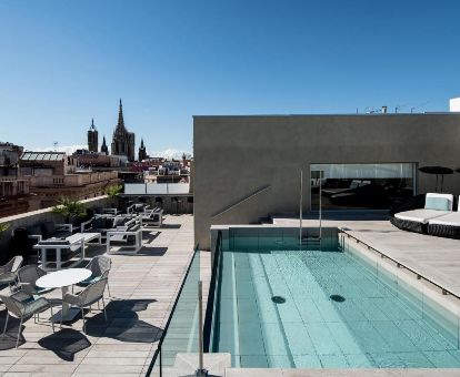 Terraza solarium con piscina y vistas a la ciudad de este moderno hotel.