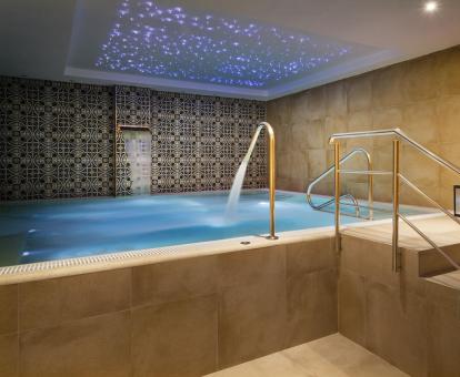 Foto de la piscina cubierta con chorros del spa del hotel.