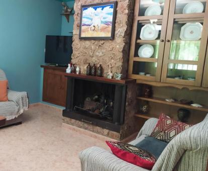 Foto de la sala de estar con chimenea y televisión de esta acogedora casa rural.