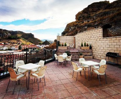 Terraza con comedores exteriores y vistas de este hotel rural.