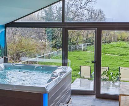 Agradable espacio de bienestar con jacuzzi y vistas a los jardines del hotel.