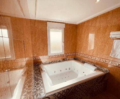 Fabuloso espacio con bañera de hidromasaje privada de una de las habitaciones de este romántico hotel.